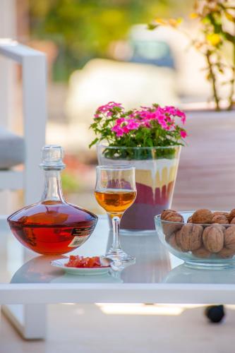 a table with a glass of alcohol and a bowl of nuts at Skandalakis Homes & Apartments in Stalos