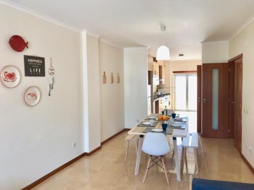 a kitchen and dining room with a table and chairs at Nazaré Beach Apartments in Nazaré