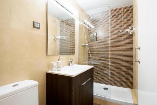 a bathroom with a sink and a toilet and a mirror at Heart of Sitges in Sitges