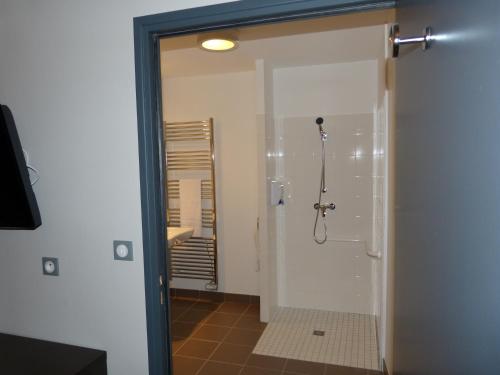 a bathroom with a shower with a glass door at Hôtel Terminus in Nantes