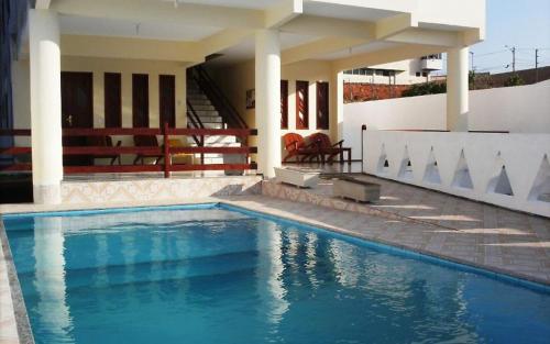 a swimming pool in front of a house at Pousada Recanto das Férias in Fortaleza