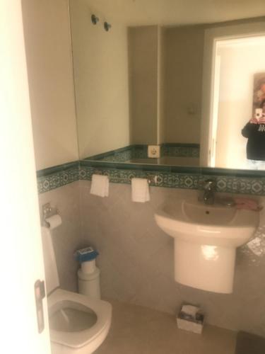 a bathroom with a toilet and a sink and a mirror at Villa 38 in Casares