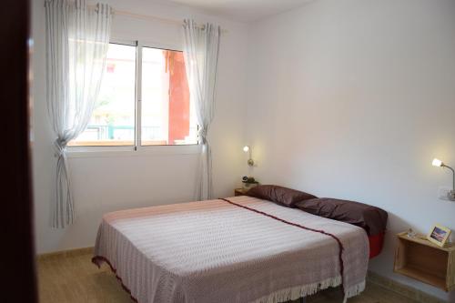een witte slaapkamer met een bed en een raam bij Caleta Relax - Apartamento Fuerteventura Apartment in La Oliva