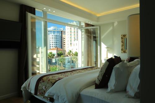 a bedroom with a bed and a large window at Brais Boutique Hotel in Durrës