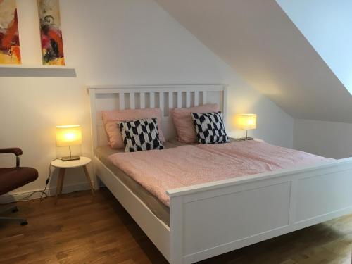 a bedroom with a white bed with two lamps on it at Über den Dächern Boppards in Boppard