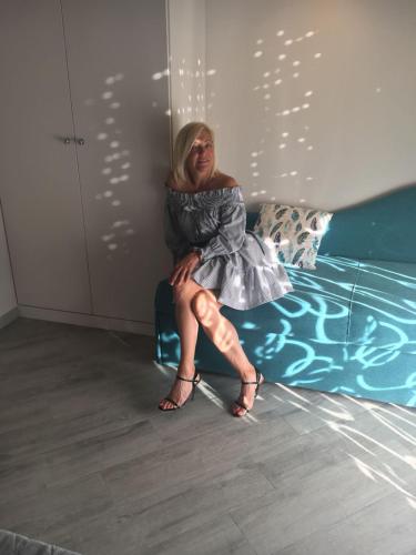 a woman in a dress sitting on a bed at B&B Da Peo in Porto San Giorgio