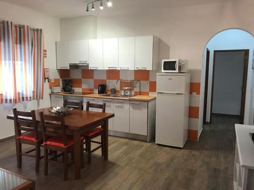 a kitchen with a table and chairs and a refrigerator at Zesty Orange by ITHOUSE in Albufeira