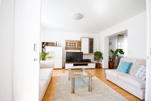 a living room with a white couch and a table at Apartma in Ormoz