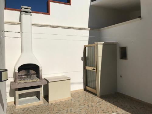 a kitchen with a stove and a refrigerator at Villetta Natalia in Torre Colimena