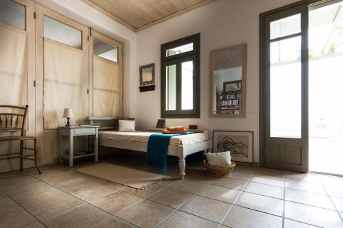 Zimmer mit einem Bett, einem Tisch und Fenstern in der Unterkunft Plori House in Skyros