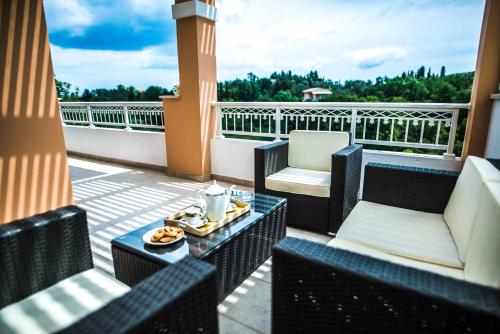 a balcony with chairs and a table with a plate of food at Villa Miranda in Gouvia