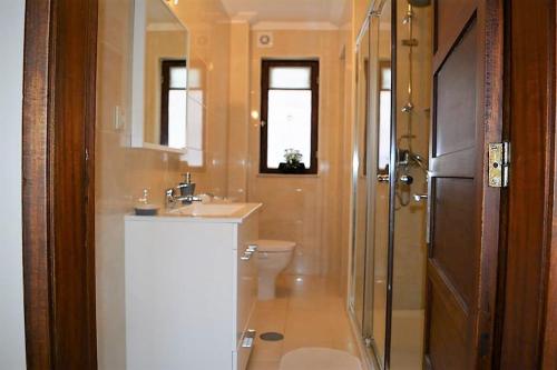 ein Bad mit einem WC, einem Waschbecken und einer Dusche in der Unterkunft Casa Praia Norte - PVZ in Póvoa de Varzim