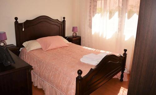 um quarto com uma cama grande e uma almofada rosa em Casa Praia Norte - PVZ em Póvoa de Varzim