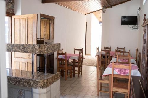 um restaurante com mesas e cadeiras e uma lareira em Pousada Sinhá Vilaça em Tiradentes