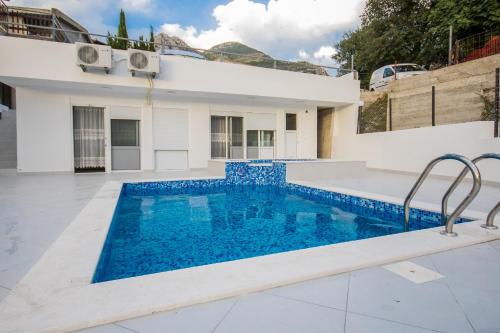 a swimming pool in front of a house at Vila Nikezić in Sutomore