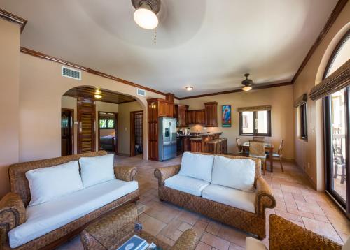 a living room with two couches and a kitchen at Coco Beach Resort in San Pedro