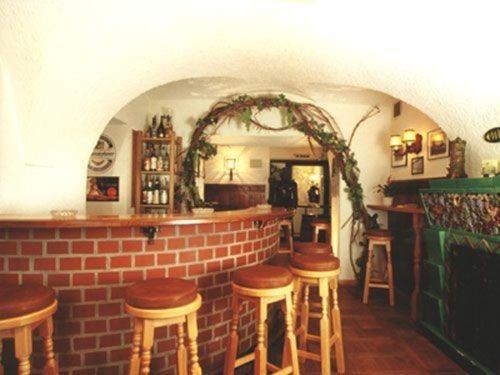 eine Bar mit Holzhockern und Ziegelwand in der Unterkunft Gasthof Kemmetmüller in Windischgarsten