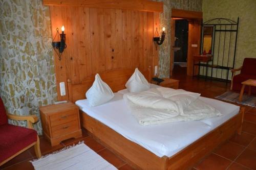 a bedroom with a bed with white sheets and pillows at Gasthof Kemmetmüller in Windischgarsten