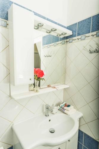 a bathroom with a white sink and a mirror at Villa Miranda in Corfu