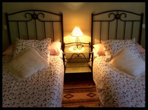 a bedroom with two beds and a lamp on a table at La Prestosa in Arriondas