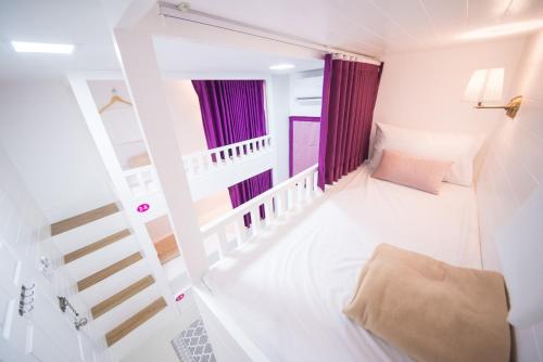 a small room with a staircase and purple curtains at The Partridge Guesthouse in Cebu City