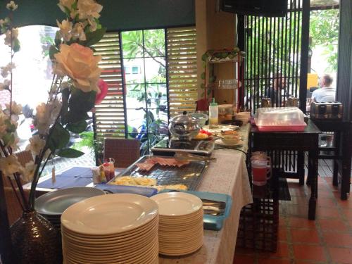 a buffet with plates and food on a table at Mandala House, Chiang Mai in Chiang Mai