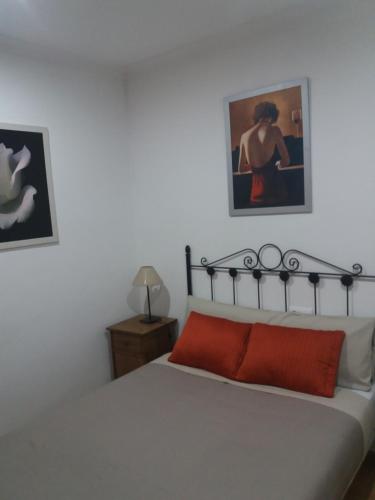 a bedroom with a bed and a painting on the wall at Antequeruela Tourists Home in Toledo