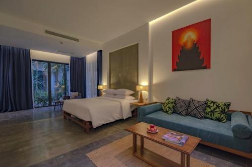 a hotel room with a bed and a couch at Silver Urban in Siem Reap