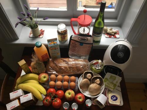 a kitchen counter with fruits and vegetables and a table with food at bluebird cottage in Angaston