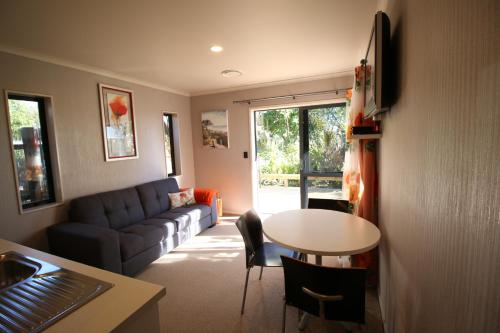 a living room with a couch and a table at The Red Hen And Dog in Ohope Beach
