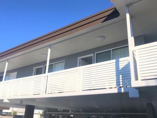 a house with a white deck on the side of it at Toukley Motor Inn in Toukley