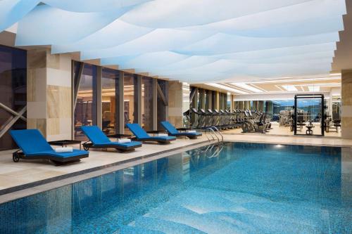 a swimming pool with blue chairs in a hotel lobby at Hyatt Regency Riyadh Olaya in Riyadh