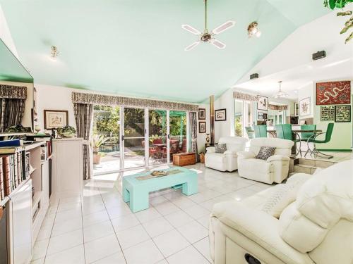 a living room with white furniture and a table at Noosa Hinterland Spectacular Boutique Guesthouse in Cooran