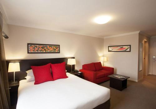 a hotel room with two beds and a lamp at Wine Country Motor Inn in Cessnock