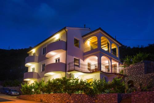 a large white building with lights on at night at Dora Apartment in Senj