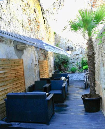 a patio with blue chairs and a palm tree at Chambres Boufflet in Laon
