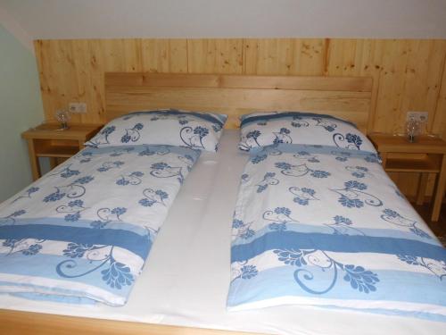 
two beds with blue pillows and pillows on them at Annas Ferienwohnung in Rappottenstein
