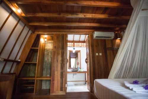 a small room with a bed and a window at Island View Bar & Bungalow in Gili Air