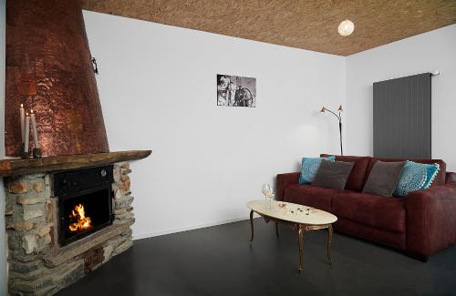 a living room with a couch and a fireplace at La Forge de Diogne - luxury B&B and apartments in Crans-Montana