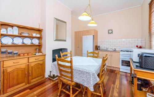 a dining room with a table and a kitchen at Eliza 1875 Red Brick Duplex Townhouse in Grafton