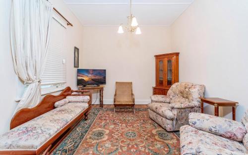 a living room with a couch and two chairs at Eliza 1875 Red Brick Duplex Townhouse in Grafton