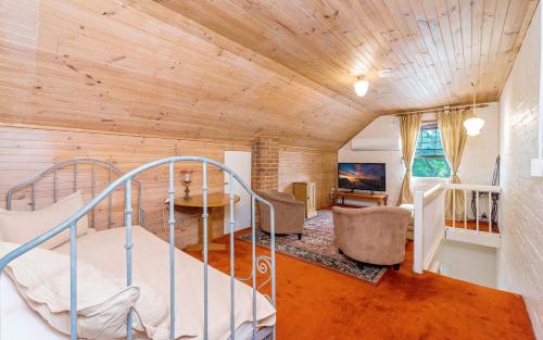 a bedroom with a bed in a room with wooden ceilings at Eliza 1875 Red Brick Duplex Townhouse in Grafton