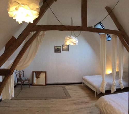 a bedroom with a canopy bed in a attic at Le Big Family - LE MONT DE LA LOUVE in Bazinghen