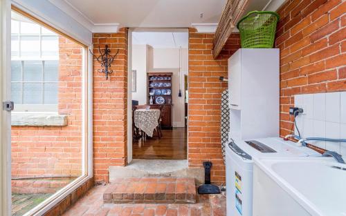 a kitchen with a brick wall and a stove at Azile 1875 Heritage Victorian Duplex in Grafton