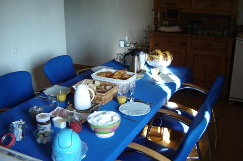 une table bleue avec de la nourriture et du pain dessus dans l'établissement Notre Cachette, à Biffontaine