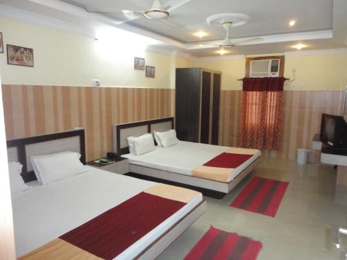 a hotel room with two beds and a tv at Hotel Green Valley in Guwahati