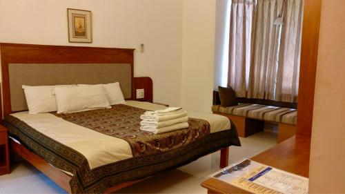 a bedroom with a bed with towels on it at Sai Towers in Puttaparthi