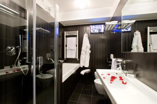 ein Badezimmer mit einem Waschbecken, einem WC und einem Spiegel in der Unterkunft Hotel Coppe Trieste - Boutique Hotel in Triest