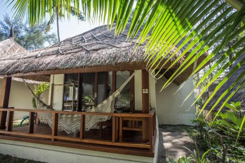 a house with a thatch roof and a porch at Island View Bar & Bungalow in Gili Air