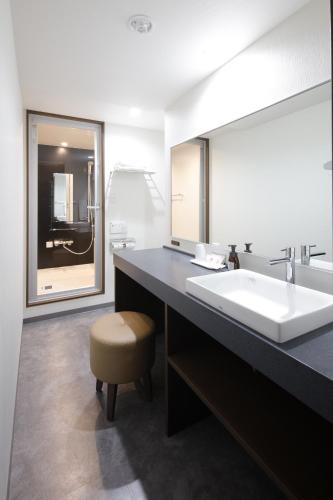 a bathroom with a sink and a large mirror at Rembrandt Style Yokohama Kannai in Yokohama